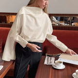 Elegante blusa de manga larga en color albaricoque con detalle de lazo