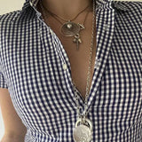 Blusa ajustada de cuadros azules con cuello polo y mangas cortas