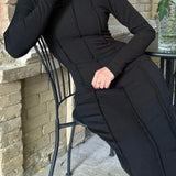 Vestido ajustado con cuello redondo y abertura.