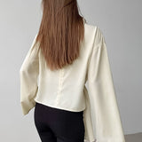 Blusa de gasa color albaricoque con mangas acampanadas y cuello alto