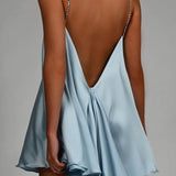 Vestido de noche sexy con detalle de cadena y espalda abierta pronunciada.