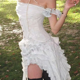 Vestido corto y fluido con espalda descubierta y bajo asimétrico con flecos.