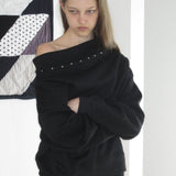 Sudadera de manga larga y hombros descubiertos adornada con tachuelas.