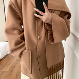 Abrigo de lana liso con bordado, cuello con pompones y bufanda.