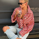 Elegante blusa roja a cuadros con cuello ancho y mangas largas.