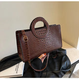 Bolso de hombro de piel sintética con estampado de cocodrilo.