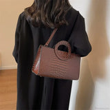 Bolso de hombro de piel sintética con estampado de cocodrilo.