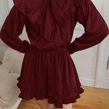 Elegante mini vestido de manga larga y encaje, adornado con lazo, corte trapecio.