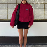 Gabardina roja con cuello alto, corte holgado y relajado, estilo streetwear.