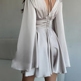 Vestido corto entallado de manga larga y escote en pico con lazo.