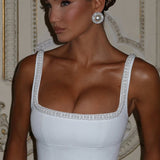 Elegante vestido de noche con tirantes de perlas.