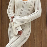 Elegante vestido largo ajustado de punto con cuello redondo, mangas acampanadas y abertura transparente.