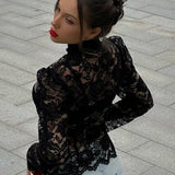 Elegante blusa con mangas abullonadas en encaje y cuello alto.