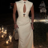 Elegante vestido largo con corte asimétrico y ribete metálico fruncido.