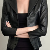 Chaqueta de cuero corta y ajustada con cuello oscuro con muescas.