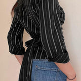 Blusa tejida a rayas con cuello y cintura con lazo, manga larga, cuello y cintura altos.