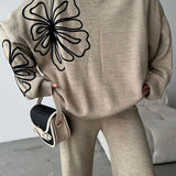 Conjunto casual de dos piezas: jersey de punto con cuello redondo y pantalón.