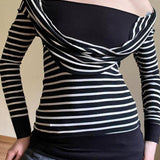 Blusa ajustada a rayas con diseño de hombros descubiertos y mangas largas.