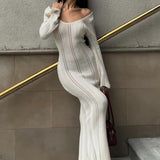 Elegante vestido largo ajustado de punto con cuello redondo, mangas acampanadas y abertura transparente.