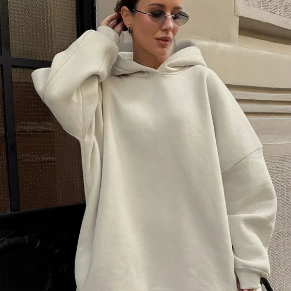 Sudadera minimalista, holgada, con capucha y hombros caídos.