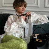 Blusa elegante y sexy con mangas acampanadas transparentes.