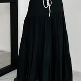 Falda larga de corte A con cintura alta y cordón en contraste, estilo bohemio chic.