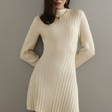Elegante y divertido mini vestido trapecio de punto con cuello alto y mangas largas.