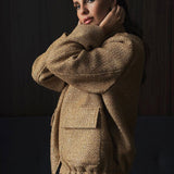 Chaqueta de lentejuelas con cuello alto y bolsillos.