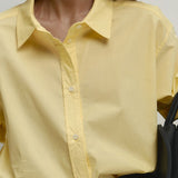 Blusa holgada de algodón amarilla con botones, ideal para uso diario.