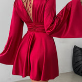 Vestido corto entallado de manga larga y escote en pico con lazo.
