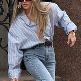 Blusa holgada de rayas con cuello y mangas largas.