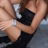 Elegante vestido sin tirantes de encaje negro con lazo floral y abertura.