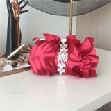 Elegante clutch de noche rojo adornado con pedrería.