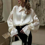 Elegante blusa de satén con mangas largas y cintura anudada, corte holgado, con cinturón para atar.