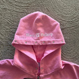 Sudadera con cremallera, bordado y pedrería.