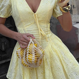 Mini vestido de algodón amarillo con bordado y lazo en la cintura.