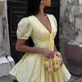 Mini vestido de algodón amarillo con bordado y lazo en la cintura.