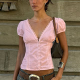Blusa con aplicaciones de encaje, escote en pico y mangas abullonadas.