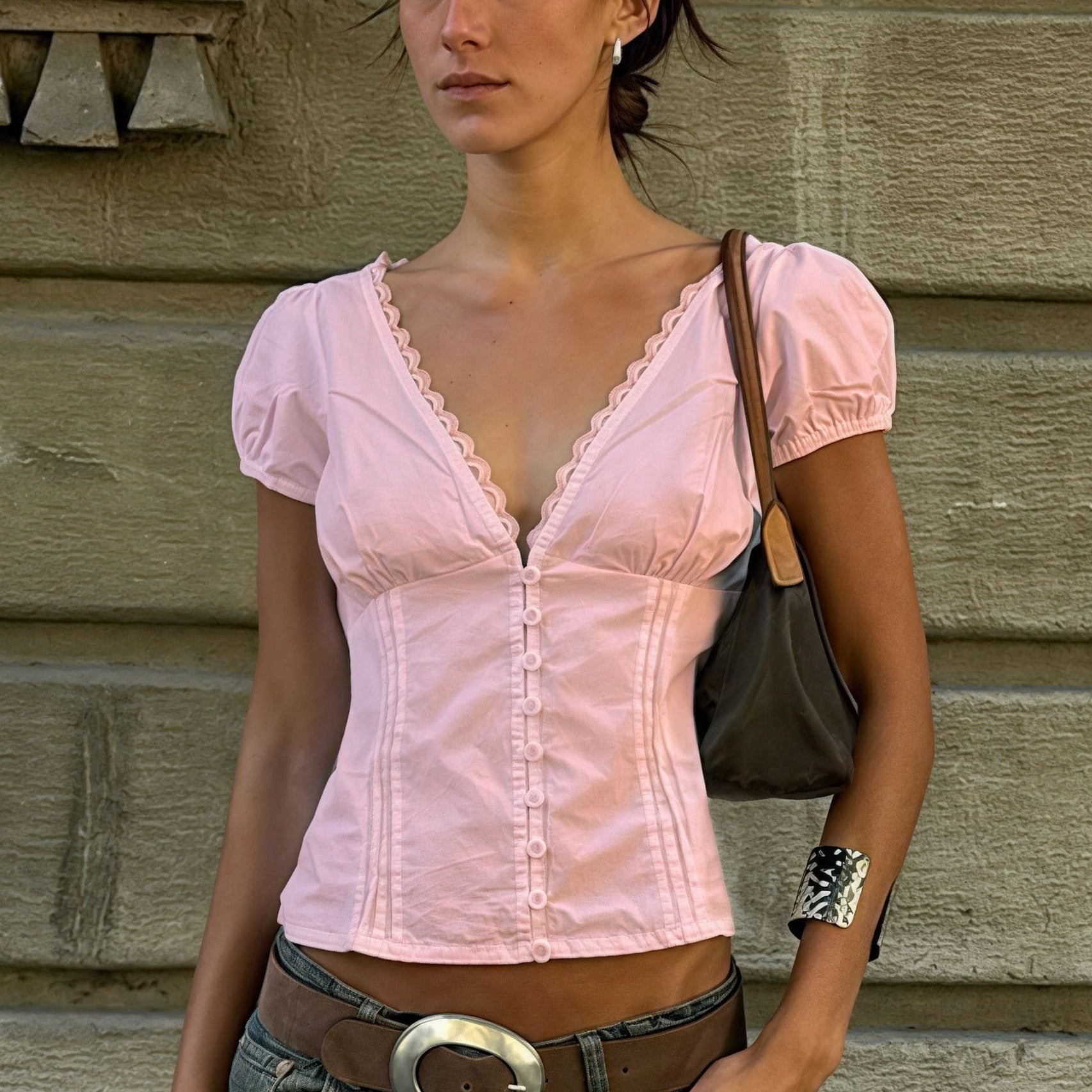 Blusa con aplicaciones de encaje, escote en pico y mangas abullonadas.