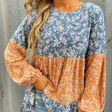 Blusa de gasa con estampado floral, cuello redondo y manga larga.