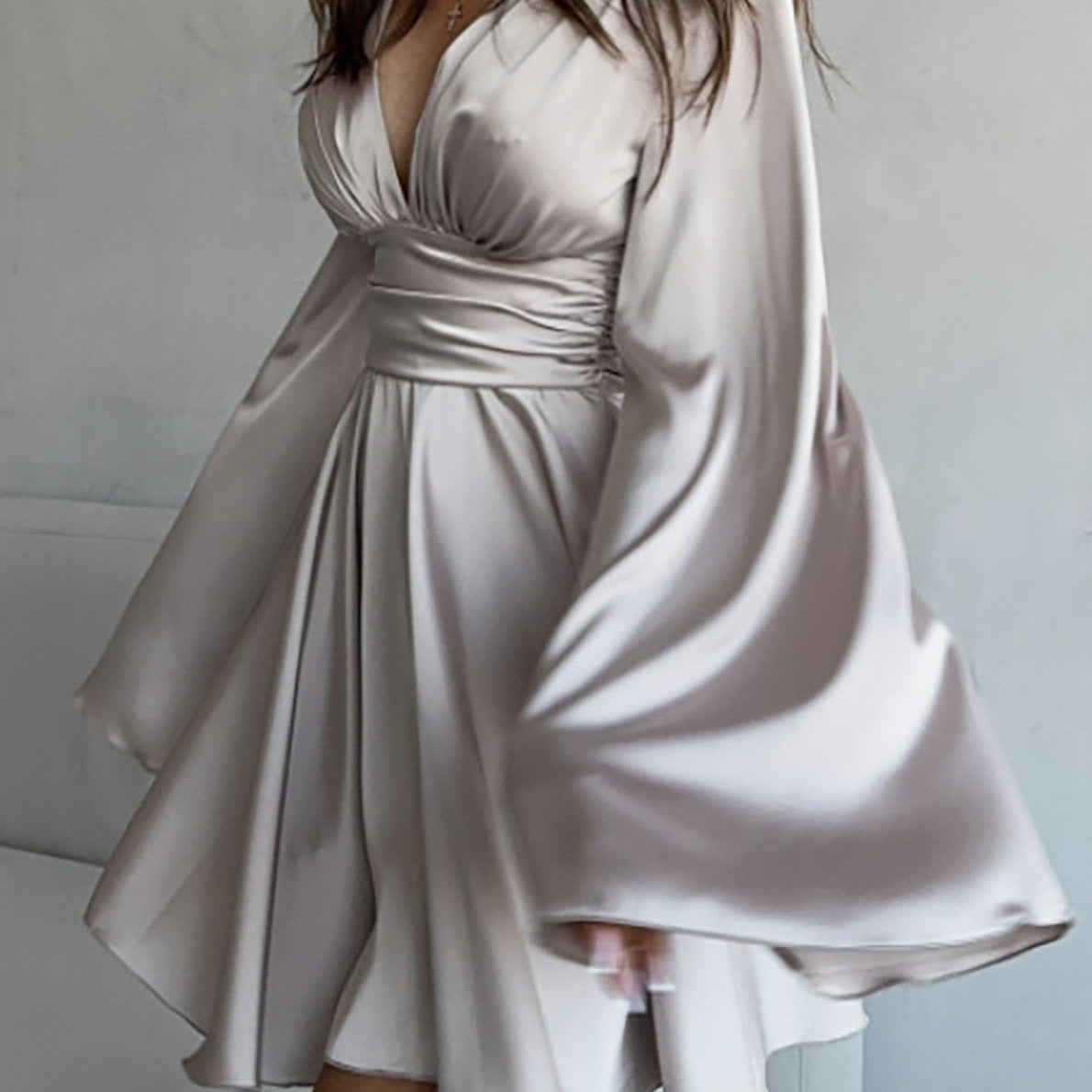 Vestido corto entallado de manga larga y escote en pico con lazo.