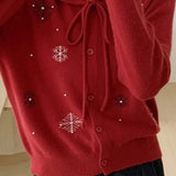 Un chaleco con cuello lavallière adornado con perlas y copos de nieve.