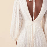 Vestido largo acampanado de jacquard con mangas abullonadas fruncidas y cierre con lazo en la espalda.