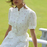 Conjunto de dos piezas con mangas abullonadas, cuello alto floral y cintura ajustada.