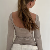 Blusa básica de rayas con cuello redondo y espalda abierta, entallada en tejido de punto.