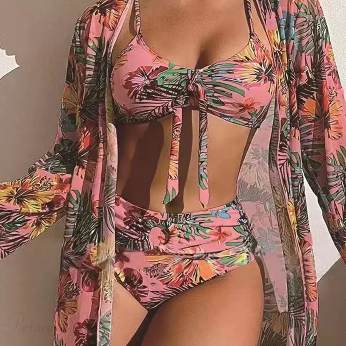 Conjunto de dos piezas con manga larga y lazo floral en la parte delantera.