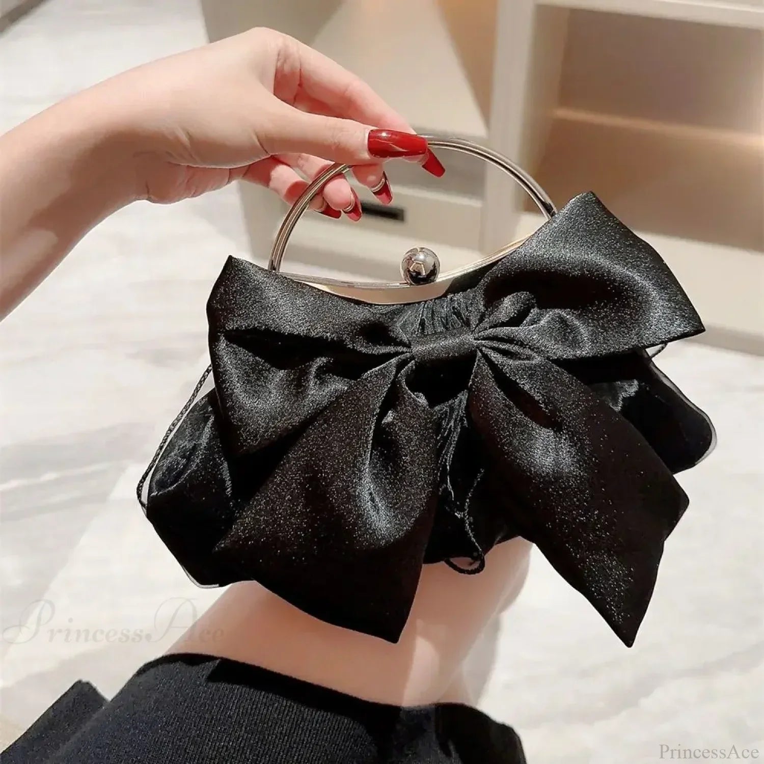Elegante bolso de noche en seda dorada con lazo, para llevar sobre el hombro.