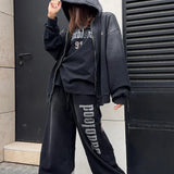 Sudadera con cremallera, letras degradadas y efecto desgastado.
