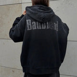 Sudadera con cremallera, letras degradadas y efecto desgastado.