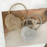Bolso de mano en forma de corazón adornado con diamantes brillantes.